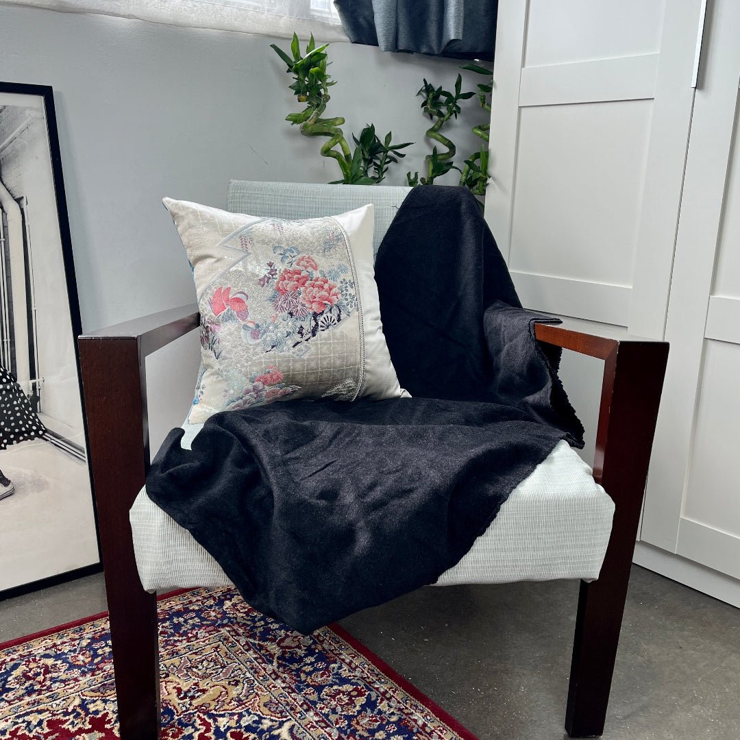Obi cushion embroidered with pink and blue mandarin ducks and flowers, resting on a chair